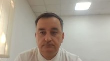 Учасник круглого столу у білій сорочці
