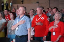 Учасники форуму співають гімн України, тримаючи руки на серці.