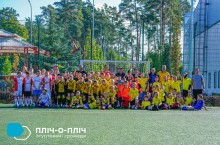 Спільне фото футбольних команд. Спортсмени одягнені у футбольну форму різного кольору.