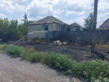 Пошкоджений будинок та трава, яка згоріла поруч через ворожий обстріл.