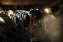 Військовий у повній екіпіровці, дивиться з наглядового пункту.