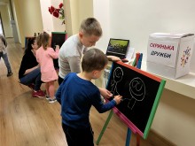 Діти малюють крейдою на дошках у межах станції «Барви дружби», поряд — скринька з написом «Скринька дружби»