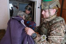 Поліцейські допомагають літній жінці одягнутись