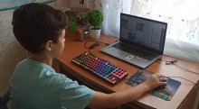 Хлопчик з Костянтинівської громади за ноутбуком під час віртуальної екскурсії Ужгородом