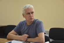 Учасник наради дивиться на екран монітора та заслуховує доповідь правоохоронців.