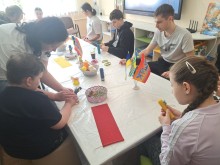Діти з особливими освітніми потребами створюють свічки з вощини під час майстер-класу, педагоги надають індивідуальну підтримку