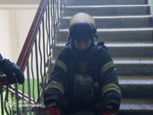 Рятувальник сидить на сходах у під'їзді.