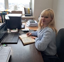 Представник військової адміністрації сидить за столом та слухає доповідача на семінарі