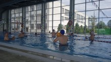 Діти грають у басейні в м'яч жовтого кольору.