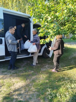 Людям з машини видають пакети з гуманітарною допомогою