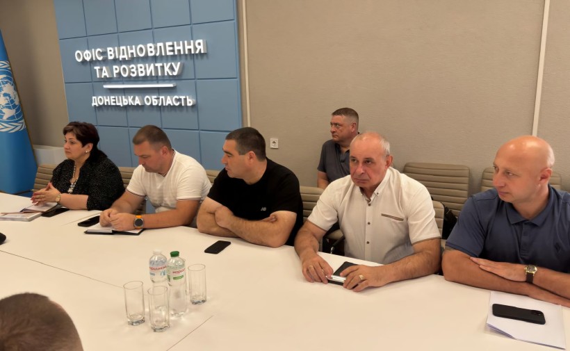 Учасники наради сидять за столом