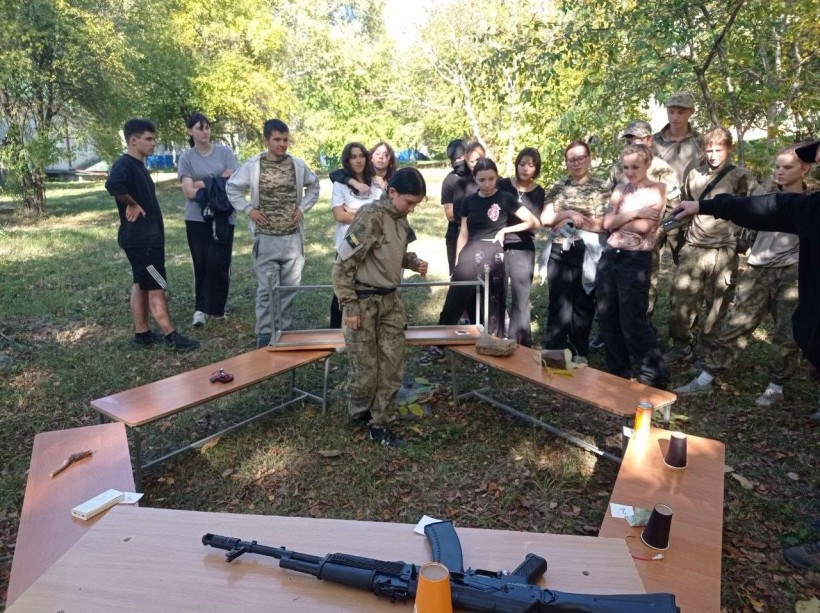 Учасники військово-патріотичного вишколу біля навчальних стендів та локацій із практичної підготовки.