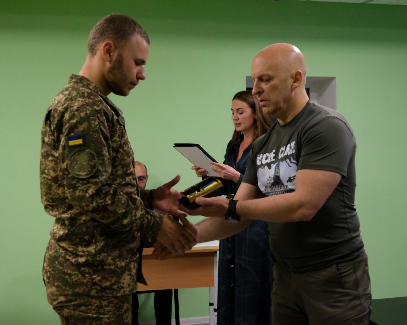 Боєць 3 бригади НГУ "Спартан" отримує нагороду з рук Вадима Філашкіна.