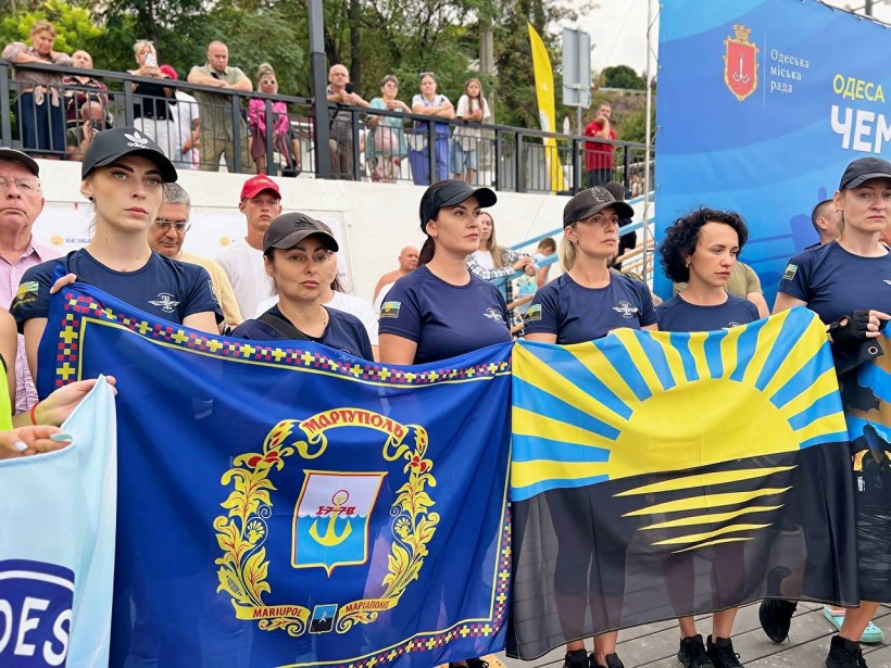 Команда поліціянток з Донеччини тримає прапори Донецької області та Маріуполя