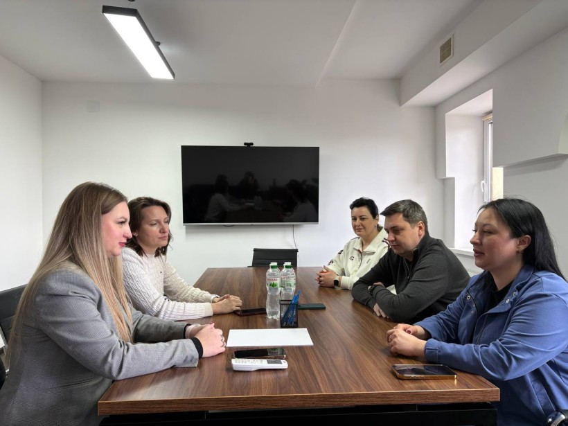 Робоча зустріч представників Ладижинської міської територіальної громади та Курахівської військової адміністрації. Представники громад сидять за столом та обговорюють питання.