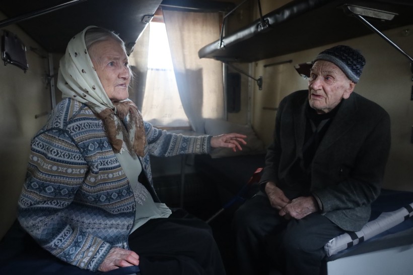 Люди старшого віку сидять у евакуаційному потязі