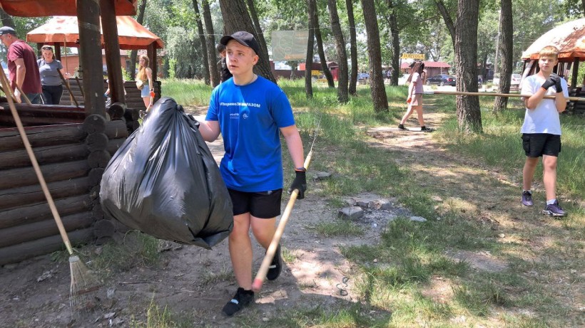 Учасник толоки несе повний пакет сміття.За кілька годин еко-толоки:
зібрано понад 15 мішків сміття.