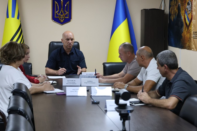 Вадим Філашкін та учасники засідання сидять за столом