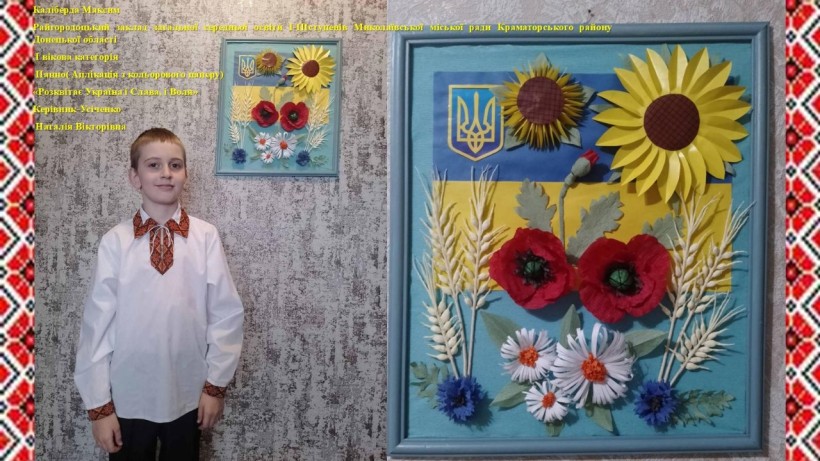 Хлопчик у вишиванці стоїть біля панно з українським прапором, соняшником, маками, ромашками та пшеницею, яку зробив власноруч.