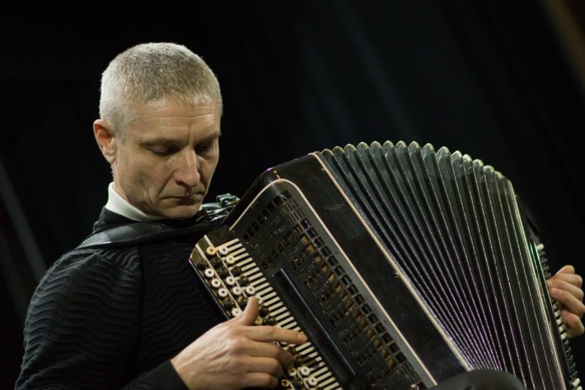 Виконавець грає на баяні.