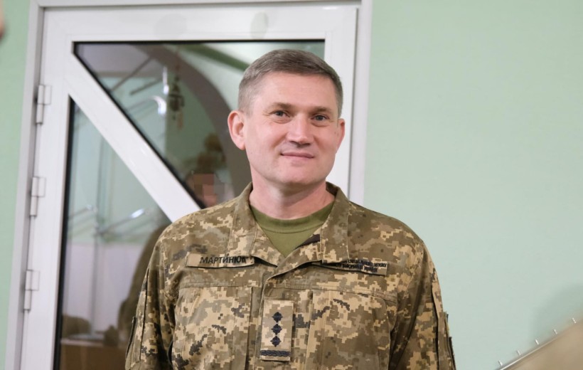 Військовослужбовець у формі стоїть біля дверей