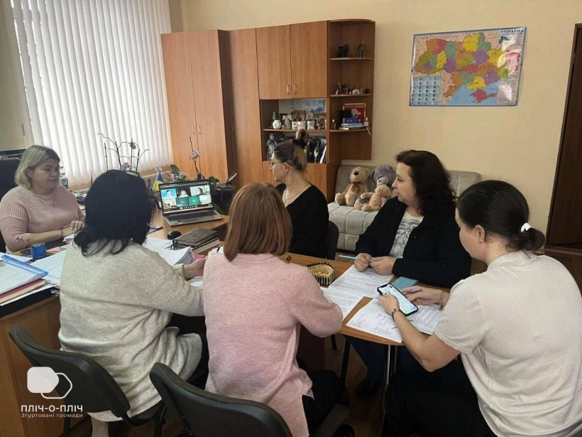 Учасниці онлайнової зустрічі між Бахмутською та Кременчуцькою громадами сидять за столом перед ноутбуком