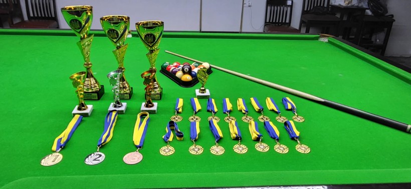 Кубки та медалі на більярдному столі