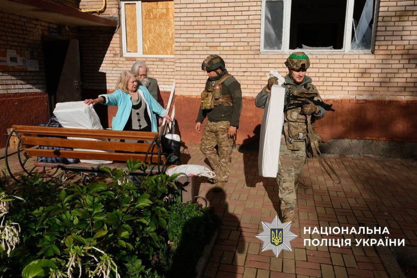 Поліцейські допомагають з евакуацією жінці