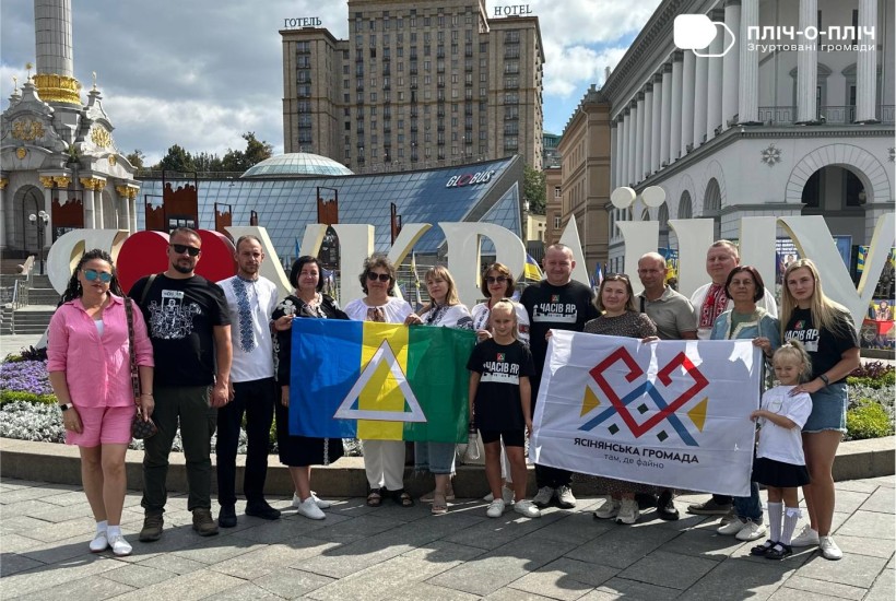 Представники громад тримають прапори. Позаду них готель Україна. Дія на Майдані Незалежності.