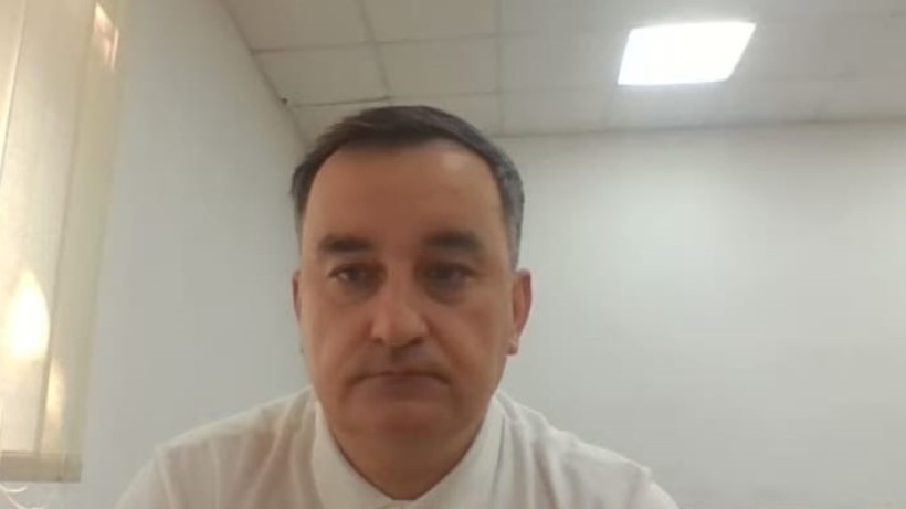 Учасник круглого столу у білій сорочці