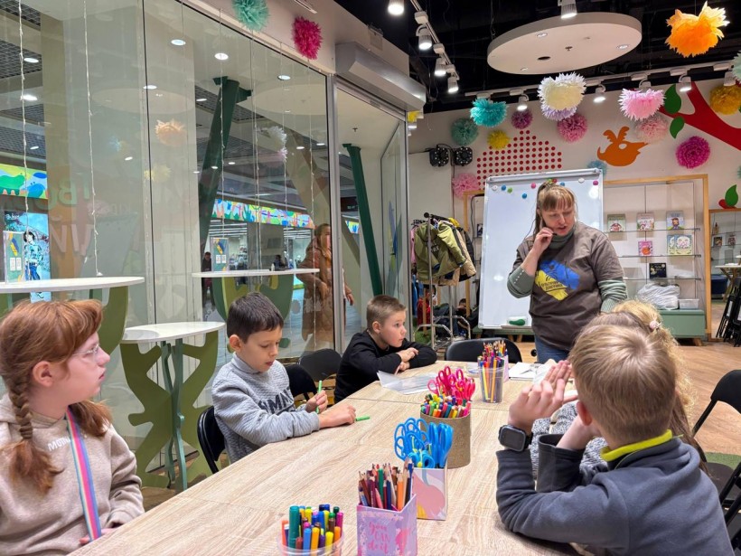 Юні гості хабу слухають наставницю на майстер-класі