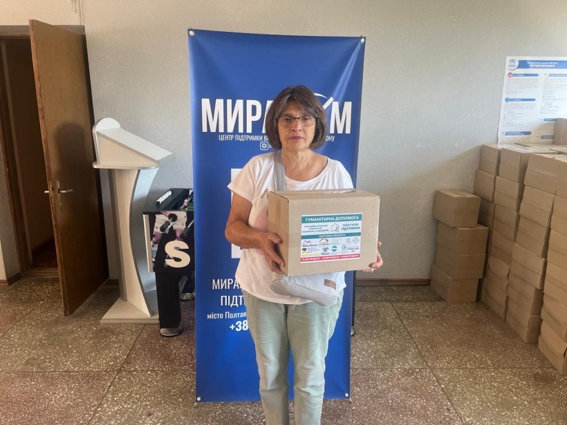 Жінка отримує благодійну допомогу