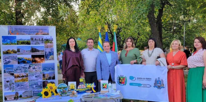 Делегація Торецької громади  на святкуванні Дня міста Канева. Представники стоять біля столу, на якому сувенірна продукція.