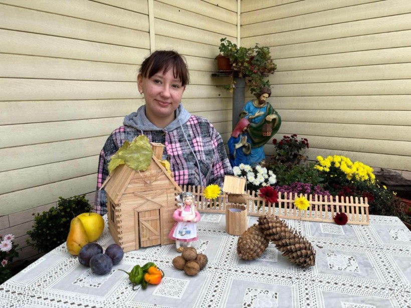Вихованка Донецького обласного центру технічної творчості дітей та юнацтва демонструє поробку з дерева та дарів осені: фрукти, овочі та шишки.
