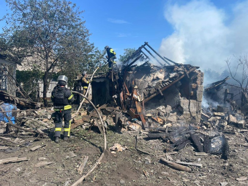 Пожежники гасять будівлю, яку зруйнували окупанти.