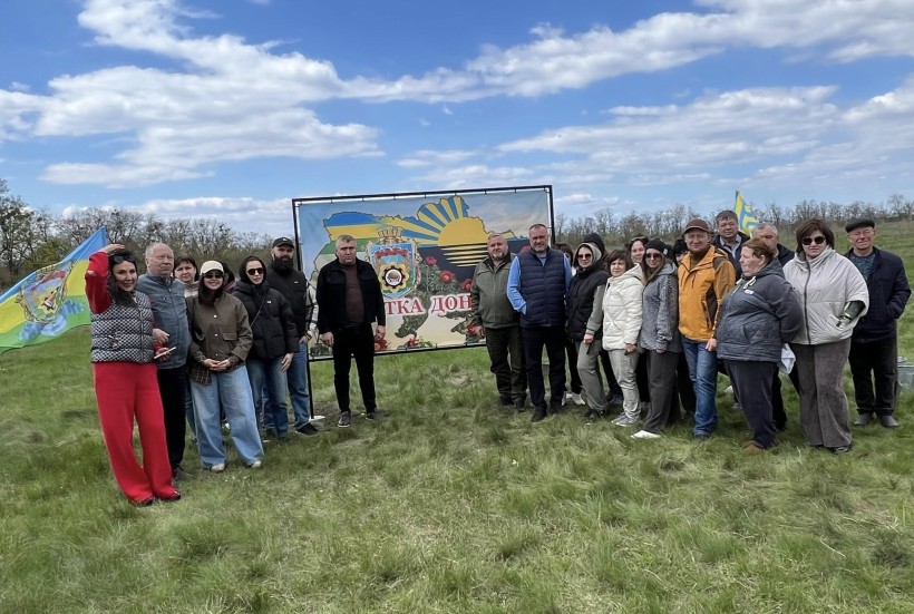 Спільне фото представників громади. Позаду банер з логотипом Донецької області.