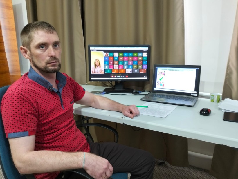 Доповідач департаменту соціального захисту населення облдержадміністрації сидить за столом та слухає доповідача на семінарі