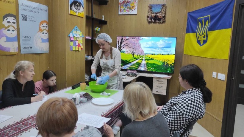 Відвідувачі жіночого клубу «Квітка надії», який працює на базі центру підтримки ВПО Маріупольського району «Серце Сходу», беруть участь у кулінарному майстер-класі.