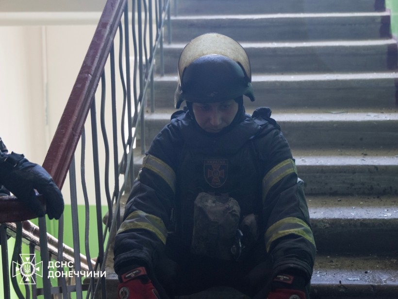 Рятувальник сидить на сходах у під'їзді.