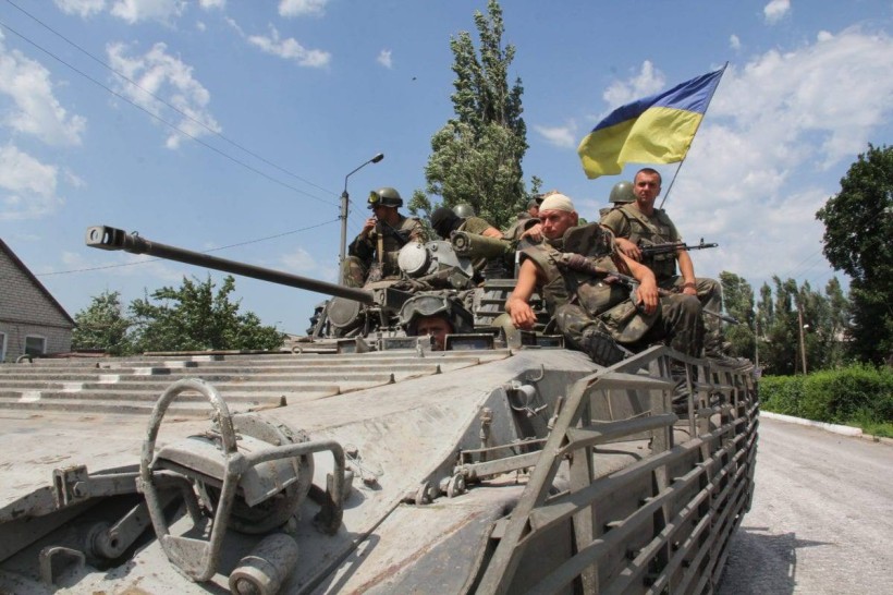 Солдати Збройних сил України, які брали участь у операції звільнення Сіверська у 2014 р. Сидять зверху на танку, поруч майорить прапор України.