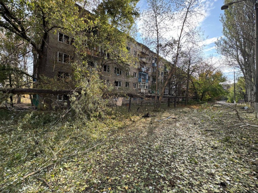 Пошкоджені дерева та багатоповерховий будинок без вікон