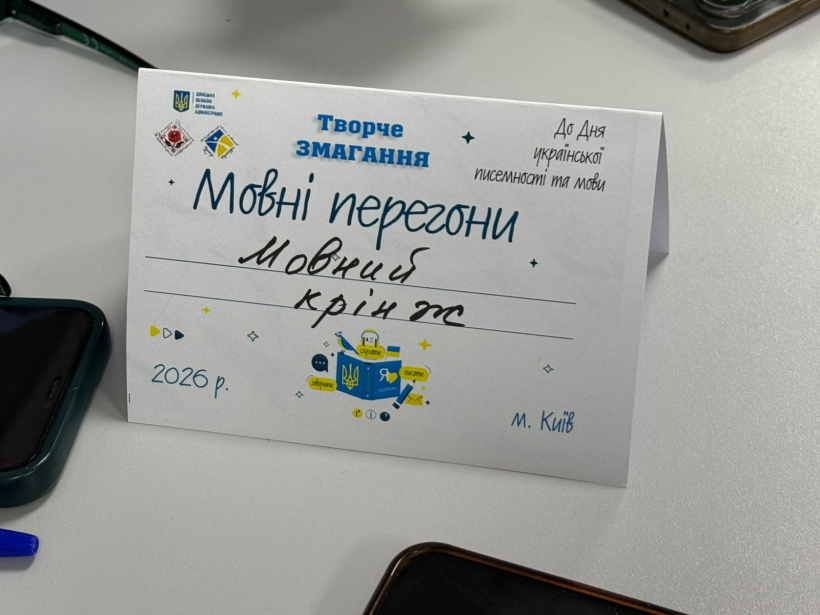 Настільна табличка з написом «Творче змагання Мовні перегони».