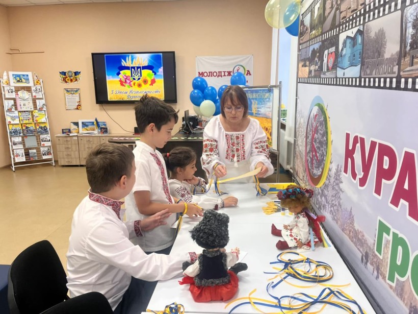Група учнів разом зі вчителем виготовляють аплікацію під час тематичних заходів до Дня Державного Прапора України та Дня Незалежності України.