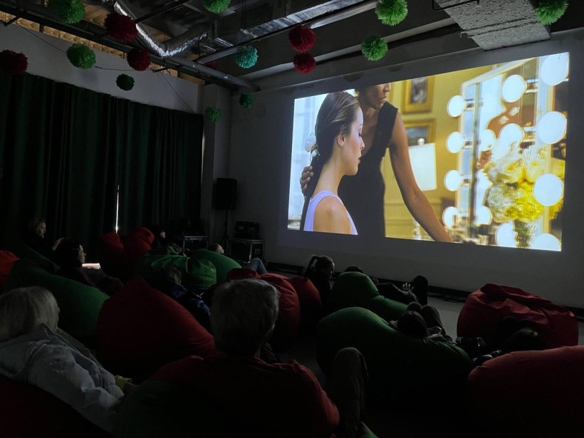 Глядачі у м’яких кріслах переглядають фільм на великому екрані