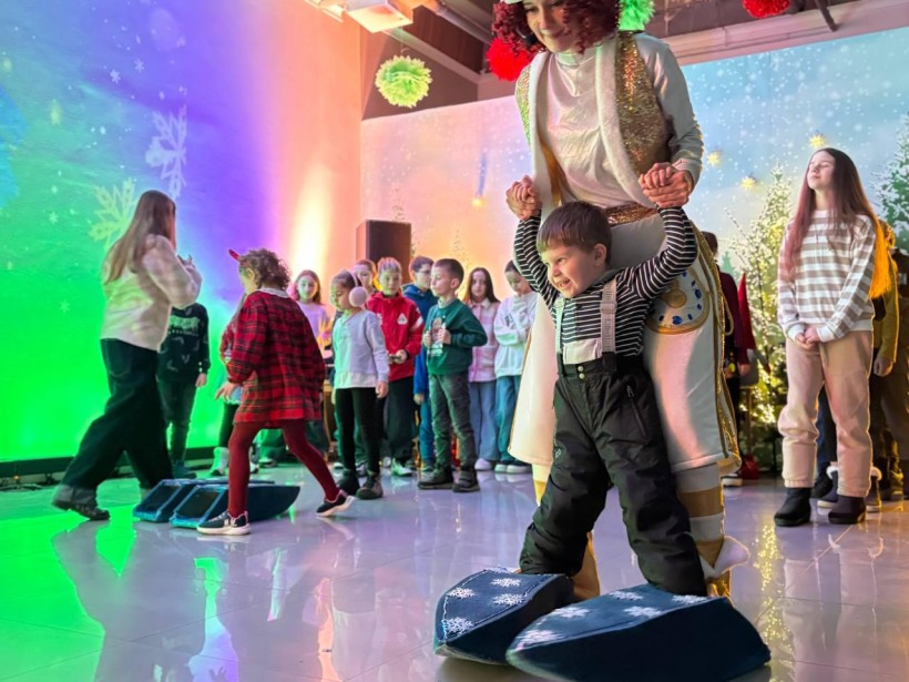 Діти грають в ігровій програмі з костюмованими аніматорами та отримують подарунки