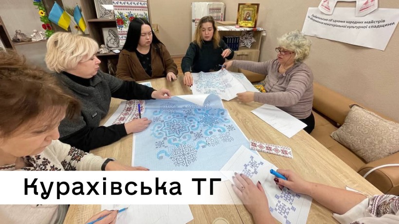 Спеціалісти Курахівської громади за столом опрацьовують ескіз майбутньої вишиванки
