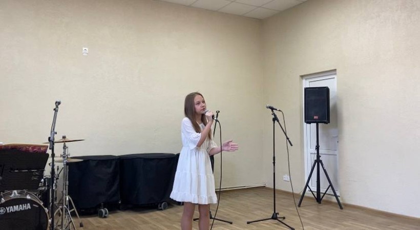 Учасниця конкурсу виконує пісню з мікрофоном