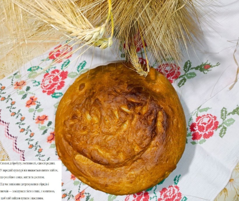 Кругла паляниця на рушнику, поруч колосся пшениці