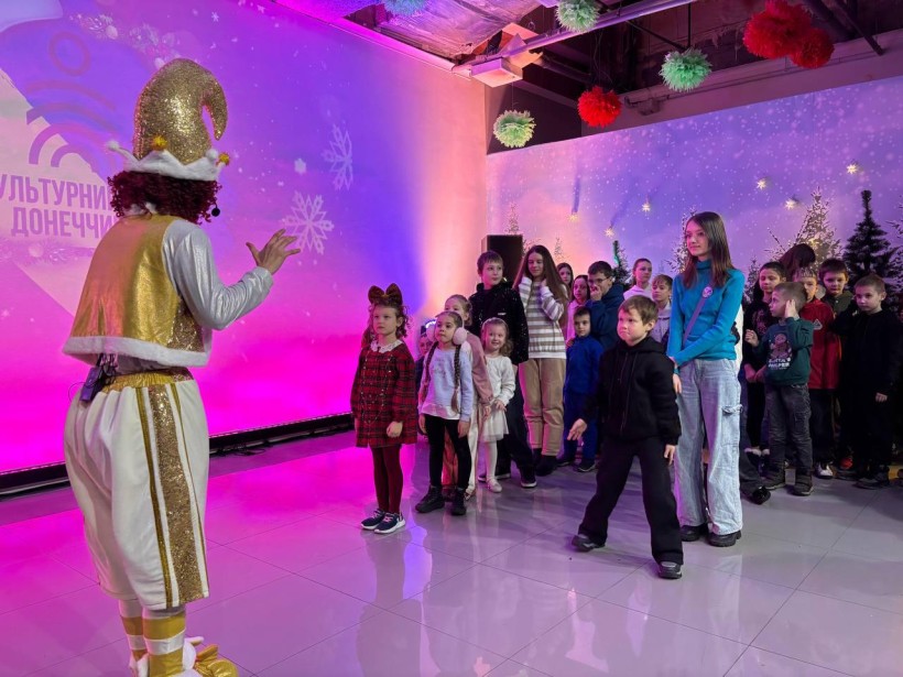 Діти грають в ігровій програмі з костюмованими аніматорами та отримують подарунки