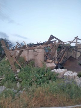 Зруйнована цегляна будівля та покрівля, знищені ворожим обстрлілом.